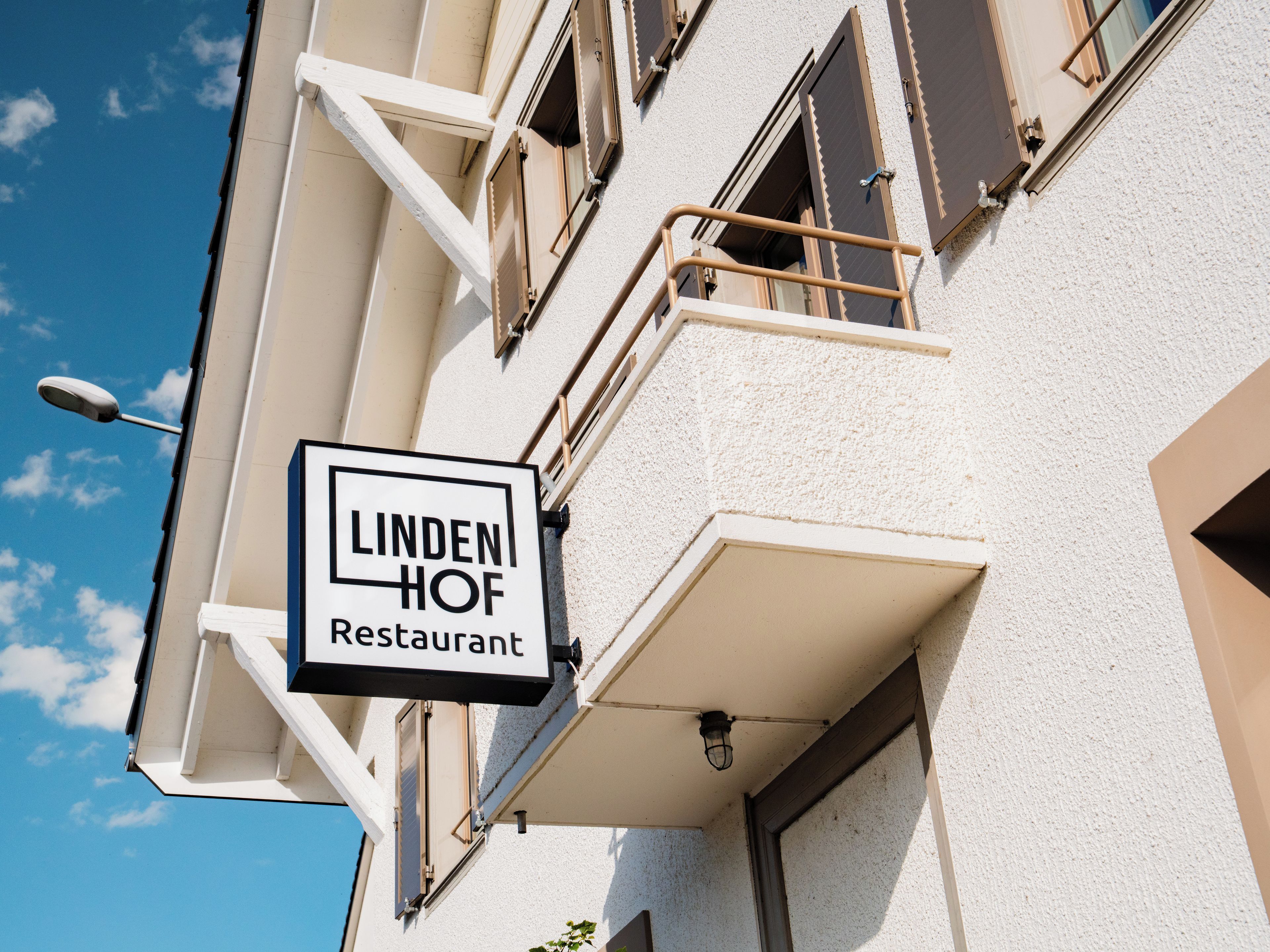 Rakennuksessa on kyltti, jossa lukee: ”Lindenhof-ravintola”.