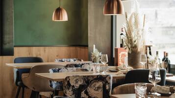 Comedor con mesa de madera, sillas e iluminación colgante.