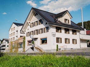 Un hotel con diseño moderno, con múltiples ventanas y una escalera que conduce a la entrada.