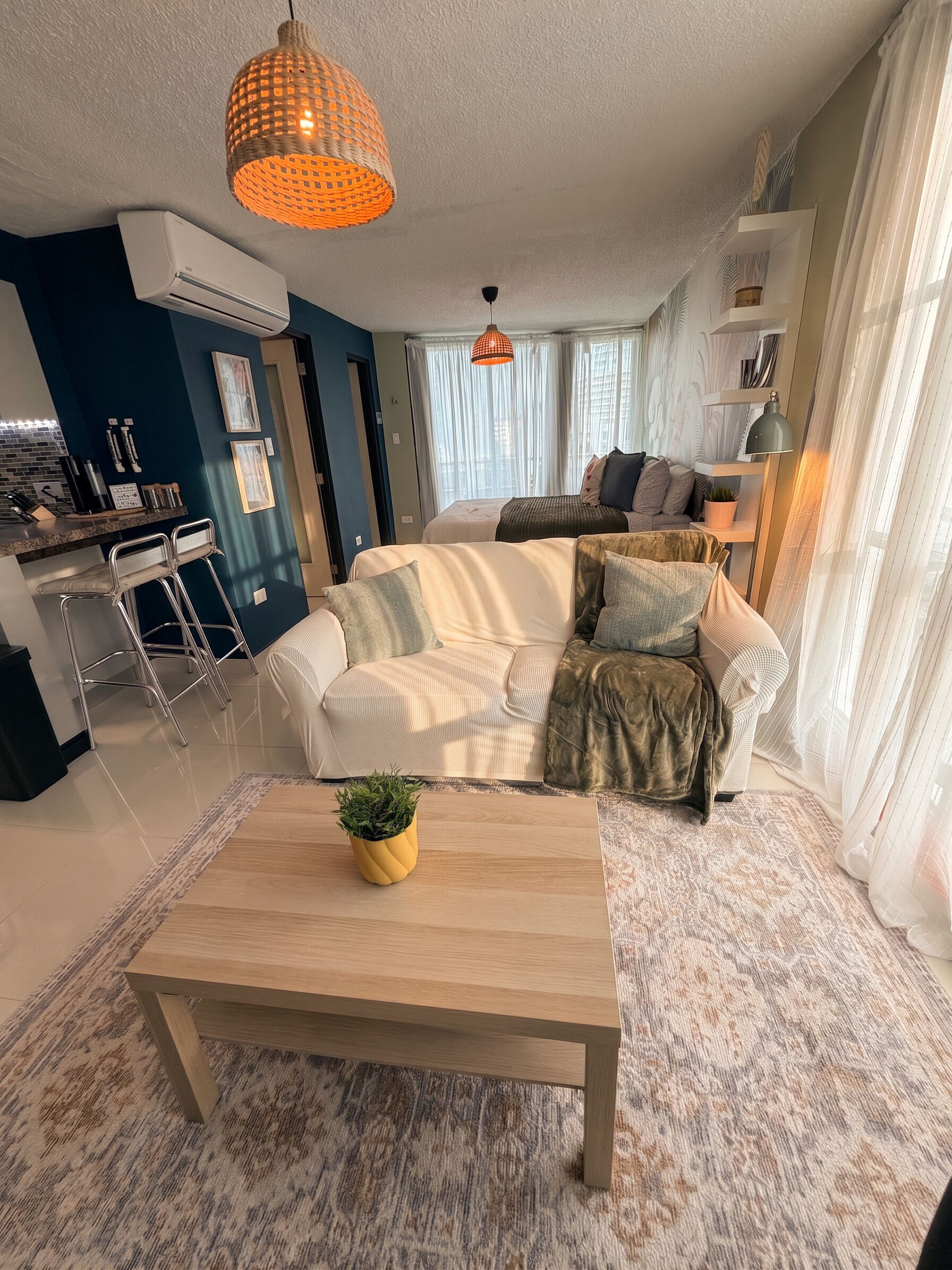A modern living room with a sofa, coffee table, and pendant lights.