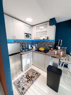 A modern kitchen with white cabinets, a black countertop, and a blue backsplash. - Ashford Imperial. Best Location. We have water! (San juan)