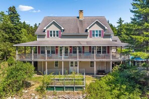 A two-story house with a balcony and a covered front porch. - 5BR Home Quietside of MDI - Sleeps 23! [Headlands] (Tremont)