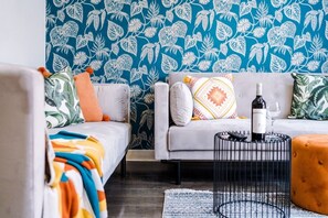 A living room with two sofas, a coffee table, and a patterned wall. - Huge 4BR 2.5BT Home - Pool Table - Etihad - COOP (Greater Manchester)