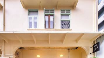 A two-story building with a balcony, a wooden door, and a sign indicating 'Heritage House'.