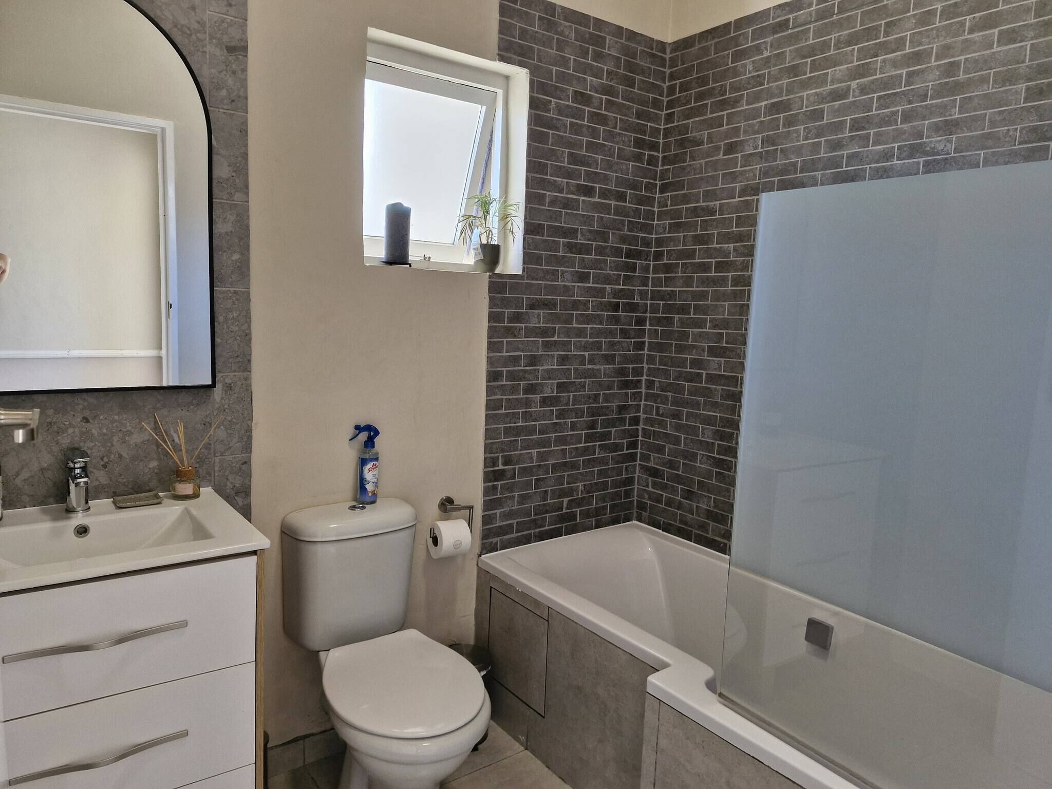 A bathroom with a toilet, sink, and bathtub.