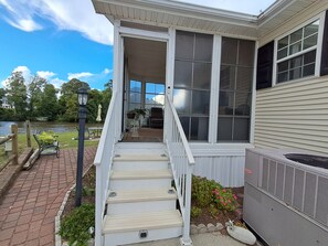 A house with a covered porch, a staircase leading to the entrance, and a view of a lake. - Cozy ICWW waterfront 2-bedroom cottage in soothing Myrtle Beach (Myrtle Beach)