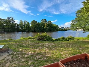 A riverside view with a grassy area, a bench, and a planter. - Cozy ICWW waterfront 2-bedroom cottage in soothing Myrtle Beach (Myrtle Beach)