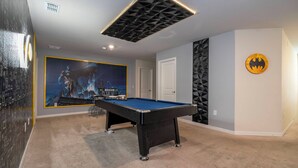 A room with a pool table, a door, and a Batman-themed wall decoration. - Stunning Windsor Island 10BR (Davenport)