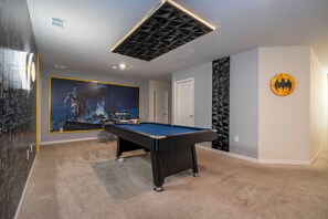 A room with a pool table, a door, and a Batman-themed wall decoration. - Stunning Windsor Island 10BR (Davenport)