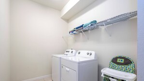 A laundry area with two washing machines, a drying rack, and a baby changing station. - Stunning Windsor Island 10BR (Davenport)