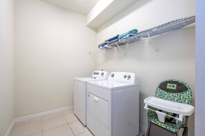 A laundry area with two washing machines, a drying rack, and a baby changing station. - Stunning Windsor Island 10BR (Davenport)