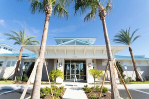 A hotel entrance with a modern design, palm trees, and a clear blue sky. - Stunning Windsor Island 10BR (Davenport)