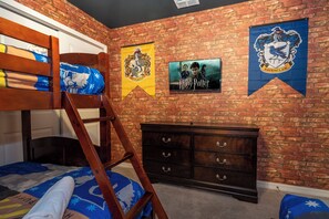 A room with a bunk bed, a dresser, and wall decorations including a Harry Potter poster and a Ravenclaw banner. - Stunning Windsor Island 10BR (Davenport)