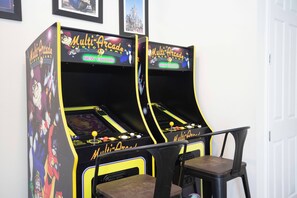 Two Multi-Arcade Video Game machines with a chair in front. - Charming 3 BR with pool at Serenity (Clermont)