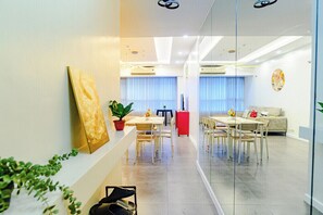 A modern living room with a dining area, a sofa, and a coffee table. - Relaxing Condo Stay in Seibu Tower (Taguig City)