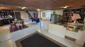 Amplia sala de estar con mesa de billar, comedor y estantería.