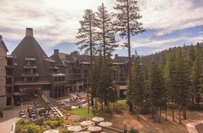 Un chalet comprenant plusieurs bâtiments, des espaces de repos en plein air et un décor de forêt en arrière-plan.