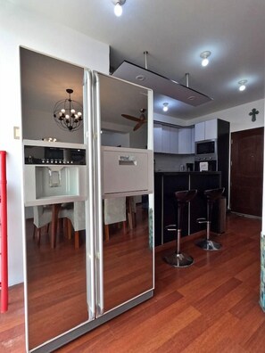 A modern kitchen with a central island, a dining area with chairs, and a bar area with stools.
