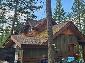 A cabin with a sloped roof, wooden walls, and a porch area.