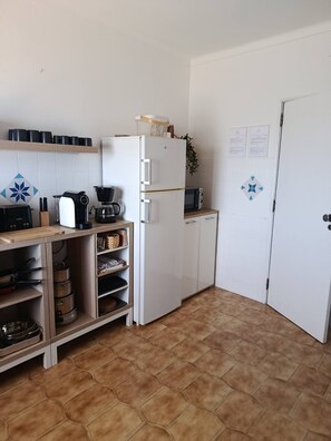 A compact kitchen with a refrigerator, microwave, and a coffee maker on the countertop. - T2 Magnificent Views (Faro)