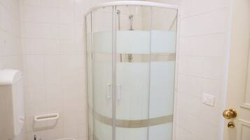 Ein Badezimmer mit einer Duschkabine, einer Toilette und einem Bidet.