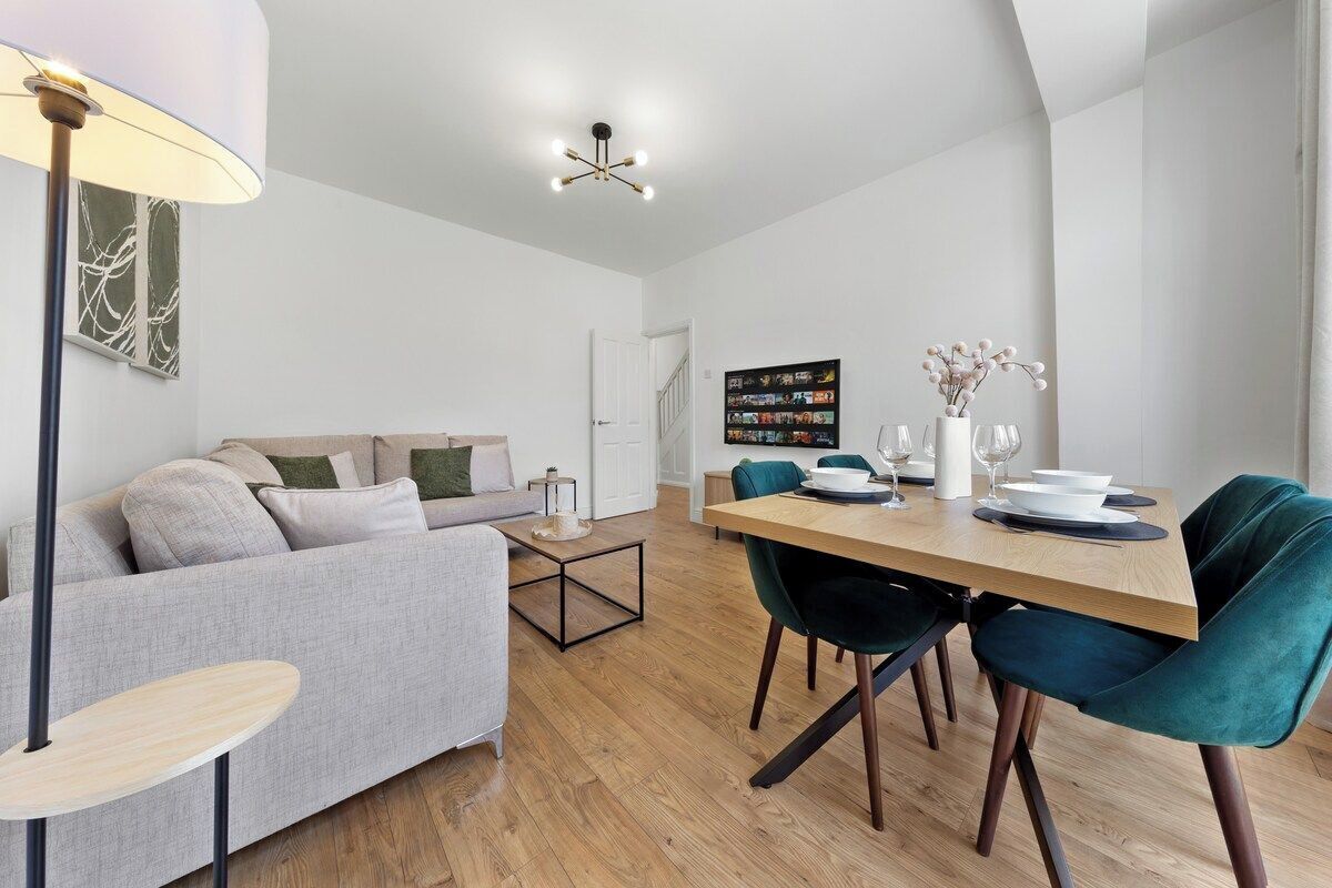 En moderne stue med sofa, spisebord med stole og sofabord.