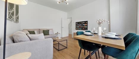 Un salon moderne comprenant un canapé, une table à manger avec des chaises et une table basse.
