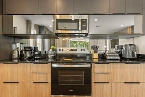 A modern kitchen with a built-in microwave, oven, and coffee maker. - Bear's Den at Reunion - Luxury 4BD/3BA (836 DM) (Kissimmee)