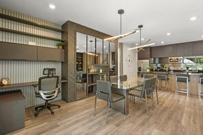 A modern office space with a central table, chairs, a desk, and a kitchenette area. - Bear's Den at Reunion - Luxury 4BD/3BA (836 DM) (Kissimmee)