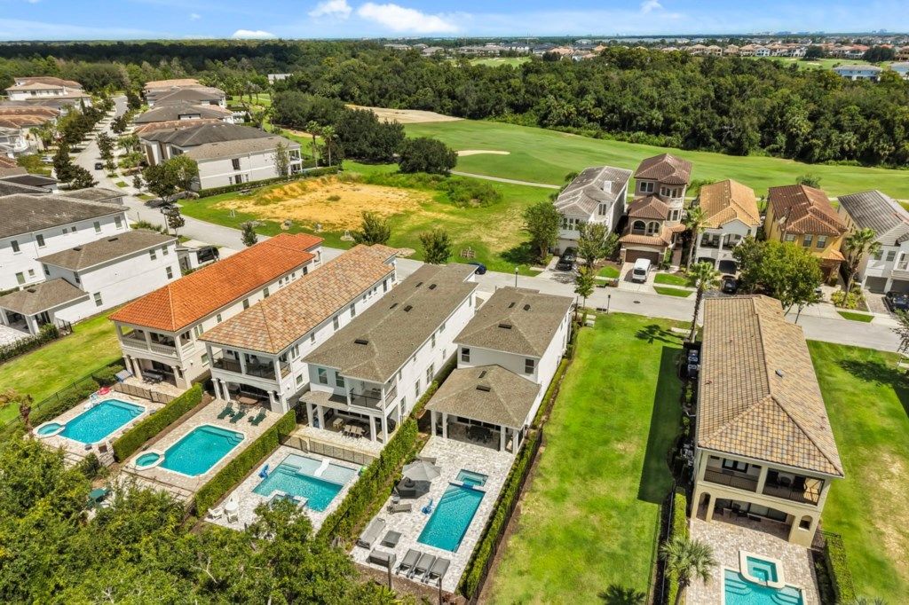A residential area with multiple houses, a golf course, and two swimming pools.