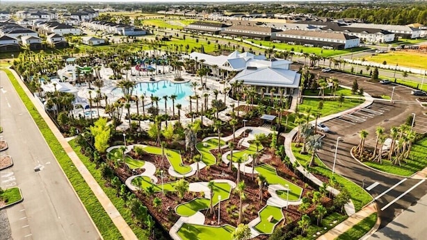 An aerial view of a resort with a swimming pool, landscaped areas, and a parking lot. - 10 BD/ 8 BA/ Windsor Cay (15906 CC) (Clermont)