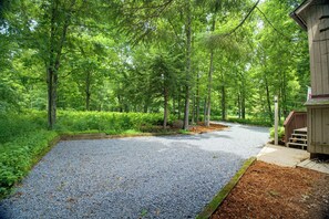 A gravel path leading through a wooded area with a wooden structure on the right. - Hot Tub, EV charger, 3 bedroom, Game room, Renovated Kitchen, 4 min to slopes (Wintergreen Resort)