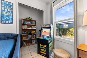 A room with a bed, a bookshelf, and a video game console. - POOL/Golf Cart/Hot Tub/Playground/Grill/Arcades (Panama City)