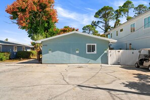 A single-story house with a garage, numbered 6202, surrounded by trees and other houses. - POOL/Golf Cart/Hot Tub/Playground/Grill/Arcades (Panama City)