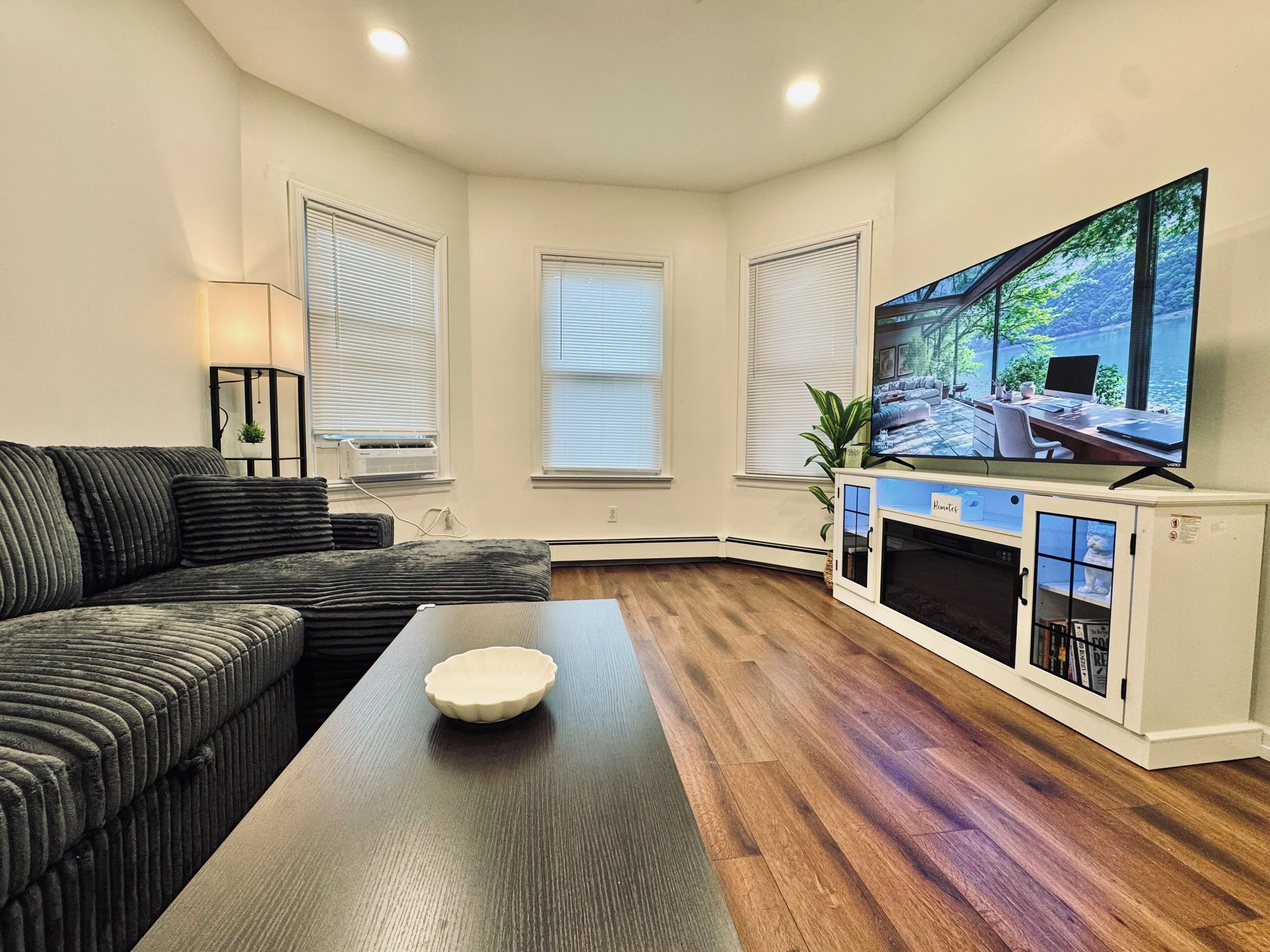 A living room with a sofa, a coffee table, a fireplace, and a television.