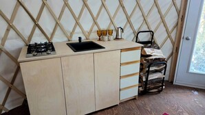 A compact kitchen with a gas stove, sink, and wooden cabinets.
