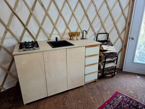 A compact kitchen with a gas stove, sink, and wooden cabinets.