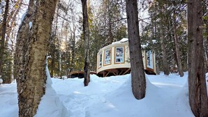 A treehouse cabin in a snowy forest.