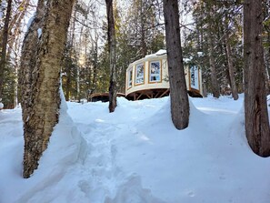 A treehouse cabin in a snowy forest.