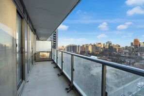 A balcony with a cityscape view, featuring a clear sky and high-rise buildings. - Heart of Downtown - 2BR - Near Dundas Square (Toronto)