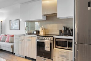 A modern kitchen with stainless steel appliances, a built-in oven, and a microwave. - Heart of Downtown - 2BR - Near Dundas Square (Toronto)