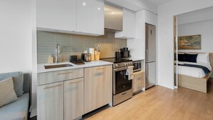 Eine moderne Küche mit Einbauofen, Kühlschrank sowie einem Essbereich mit Tisch und Stühlen.