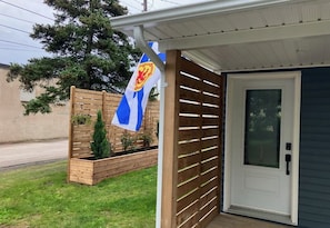 A residential property with a wooden fence, a flag, and a door.