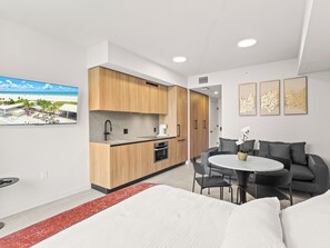 A modern hotel room with a kitchenette, a dining area, and a large bed. - Bay View Studio - Rooftop Pool - Downtown Miami (Miami)