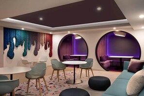 A modern lounge area with round tables, chairs, and a sofa. - *NEW* Lux Condo | High-Floor Views · Gym · Pool · (Miami)