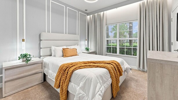 A modern bedroom with a bed, bedside tables, a nightstand, a large window with curtains, and a ceiling light. - Mickey & Mario Luxury Retreat, private pool (Kissimmee)