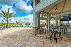 A covered outdoor area with a pool, bar, and seating. - Mickey & Mario Luxury Retreat, private pool (Kissimmee)