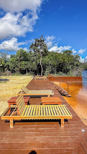 A wooden deck with benches and a railing, leading to a body of water. - Casa Summer Ville em Barreirinhas/em condomínio/piscina privativa (Barreirinhas)