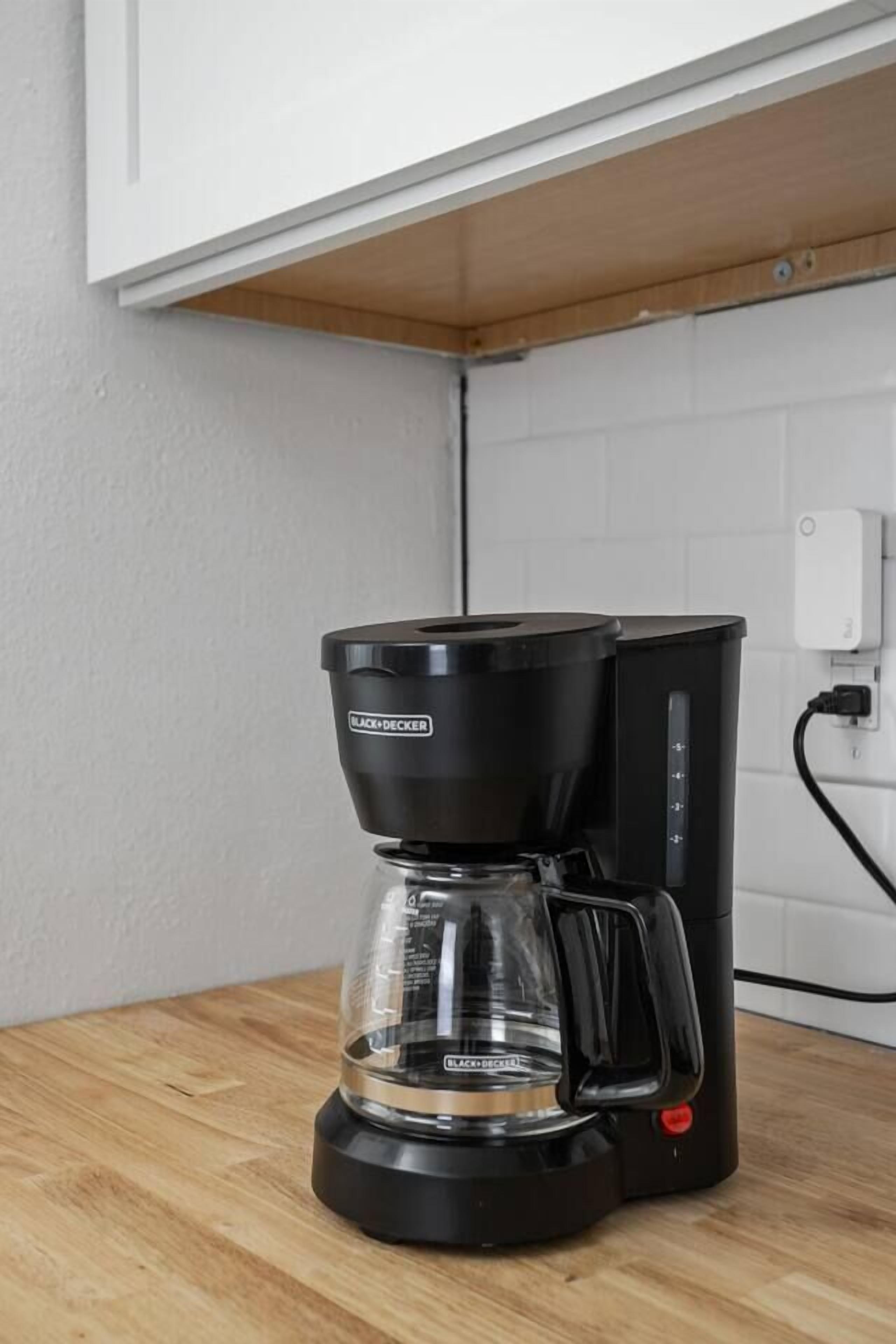 Eine Kaffeemaschine steht auf einer Holzausziehtheke.
