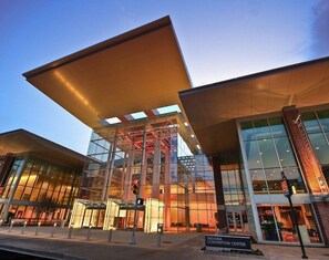 Ein modernes Gebäude mit Glasfassade, großen Überhängen und einem Schild, das anzeigt, dass es sich um das Indiana Convention Center handelt.